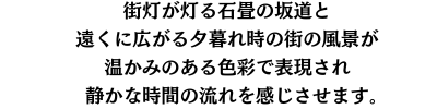 街灯が灯る石畳の坂道と遠くに広がる街の風景が、温かみのある色彩で表現され、静かな時間の流れを感じさせます。